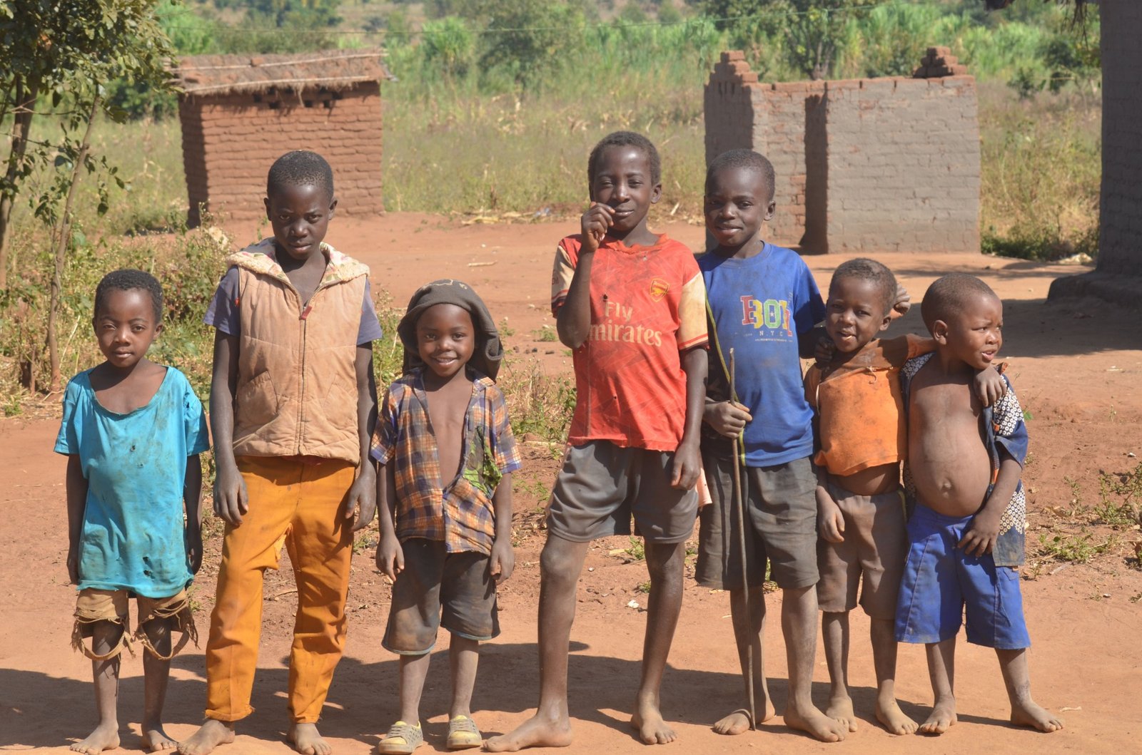 A group of children standing together outdoors in a village.